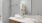 Model bathroom at our luxury apartments in Richmond, featuring white countertops, a large mirror, and stainless steel faucet.